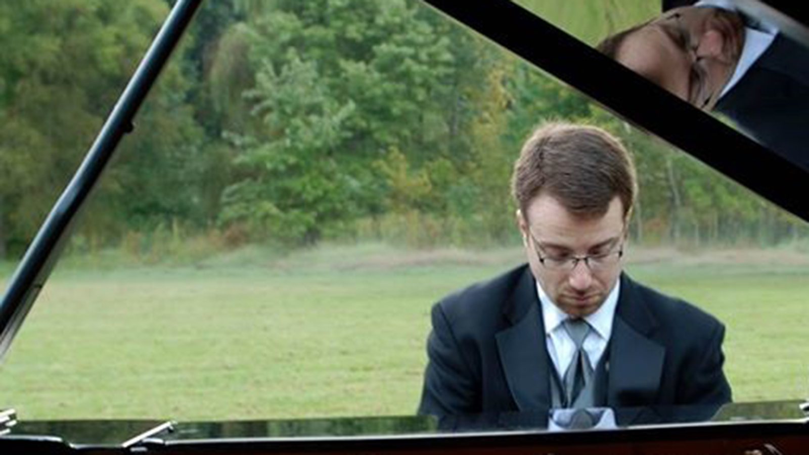 Matthew Bachman playing the piano outside.
