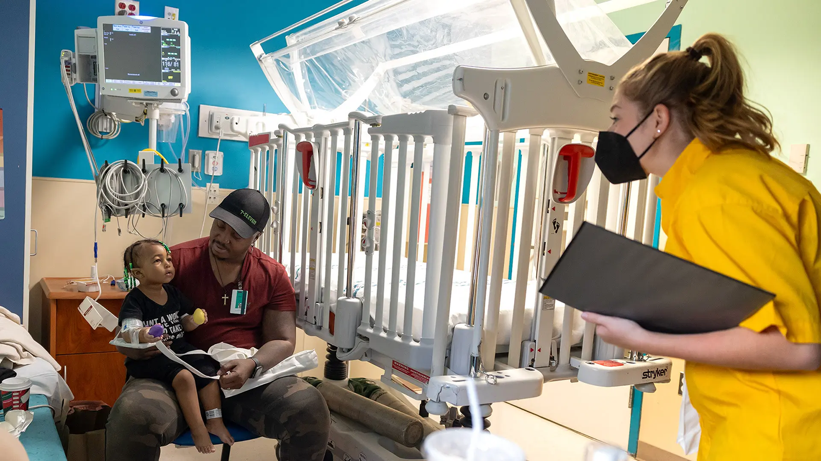 Music education major Paige Peercy ’25 (right) sings to a young patient and her father at University of Maryland Children's Hospital in Baltimore.
