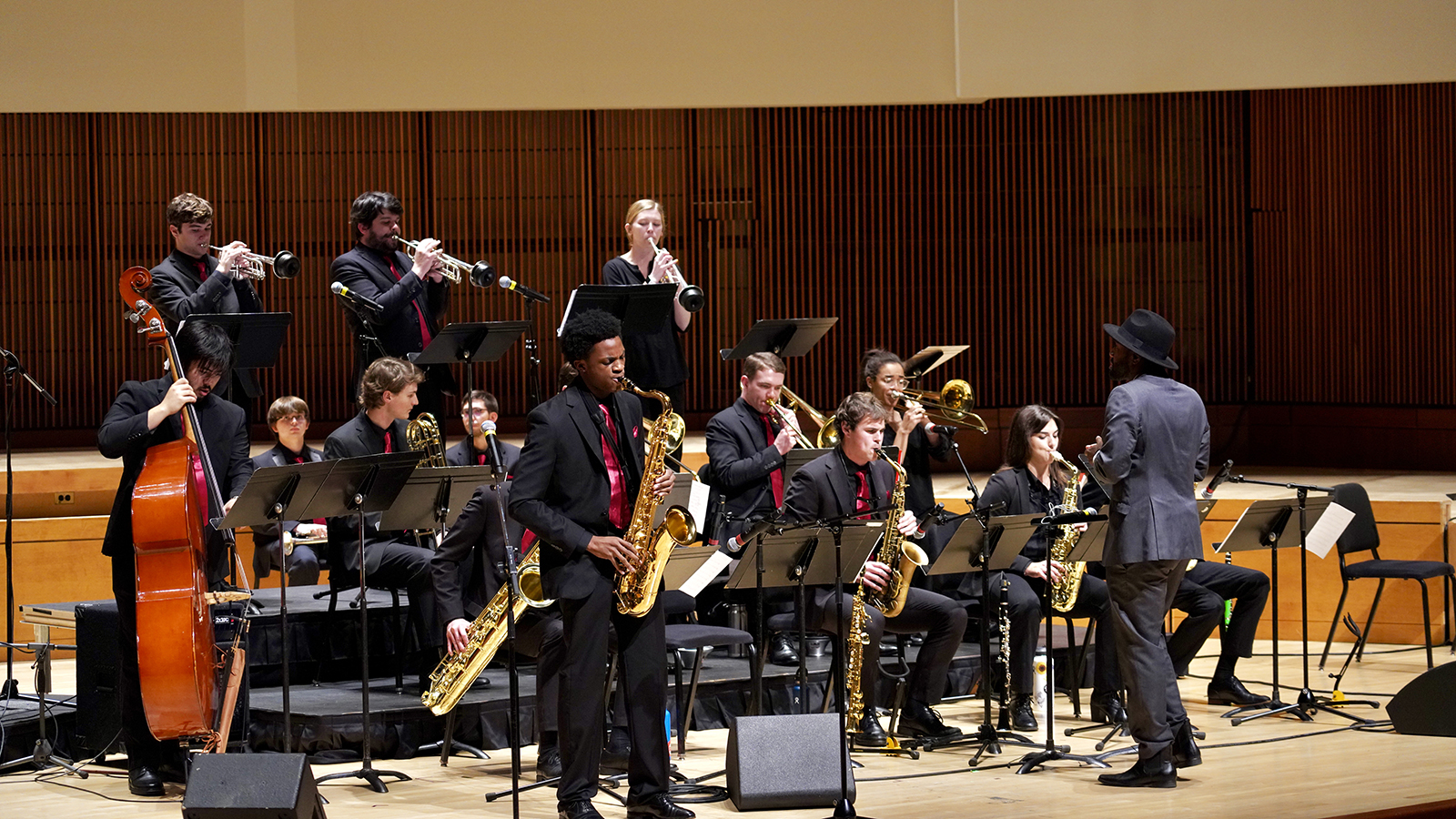 Jazz ensemble members perform on stage.