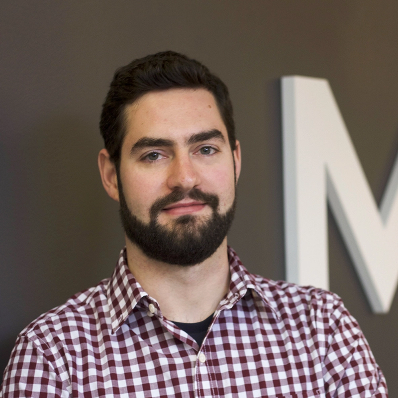 SOM Affiliate Faculty and MITH Software developer Raffaele Viglianti. He is wearing a red and white plaid shirt, and has dark hair and a beard.