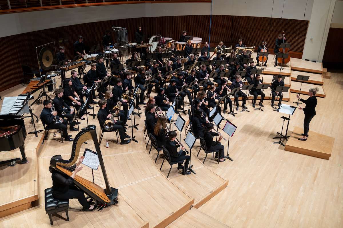 Andrea Brown conducts the UMD Wind Ensemble on stage.