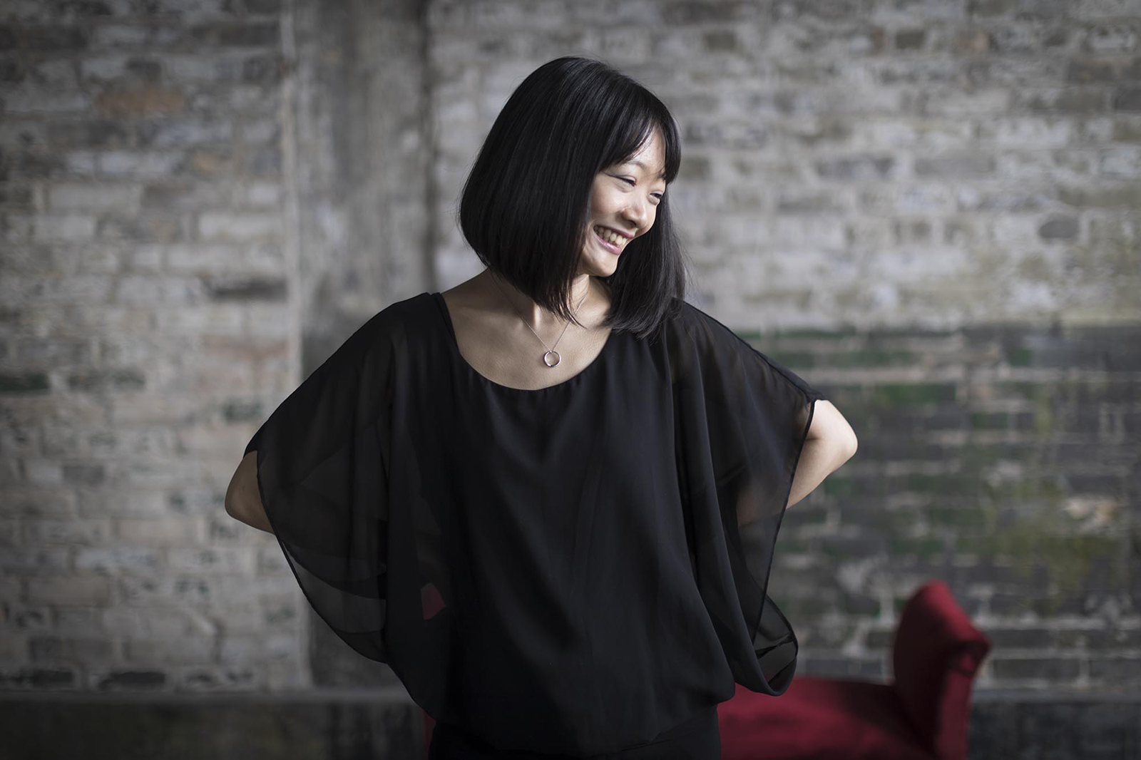 Futaba Niekawa. She is looking down towards the corner of the frame and smiling.