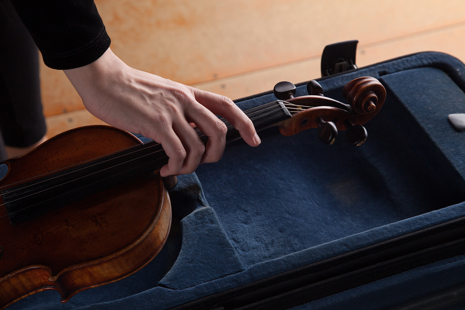 Someone pulls a violin out of it's case.