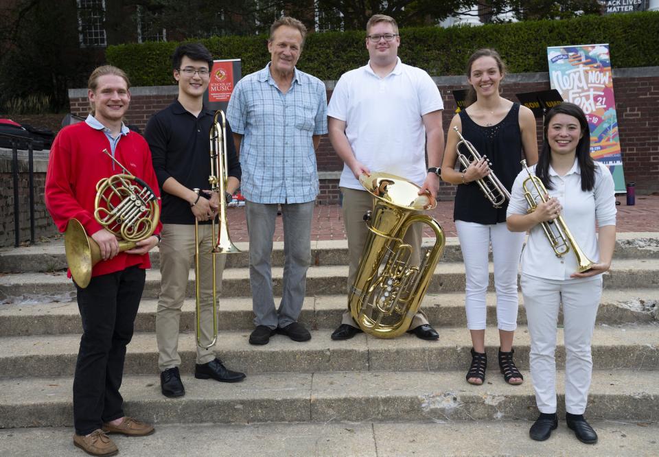  The five graduate students of Terrapin Brass stand outside on steps with Professor Chris Gekker.